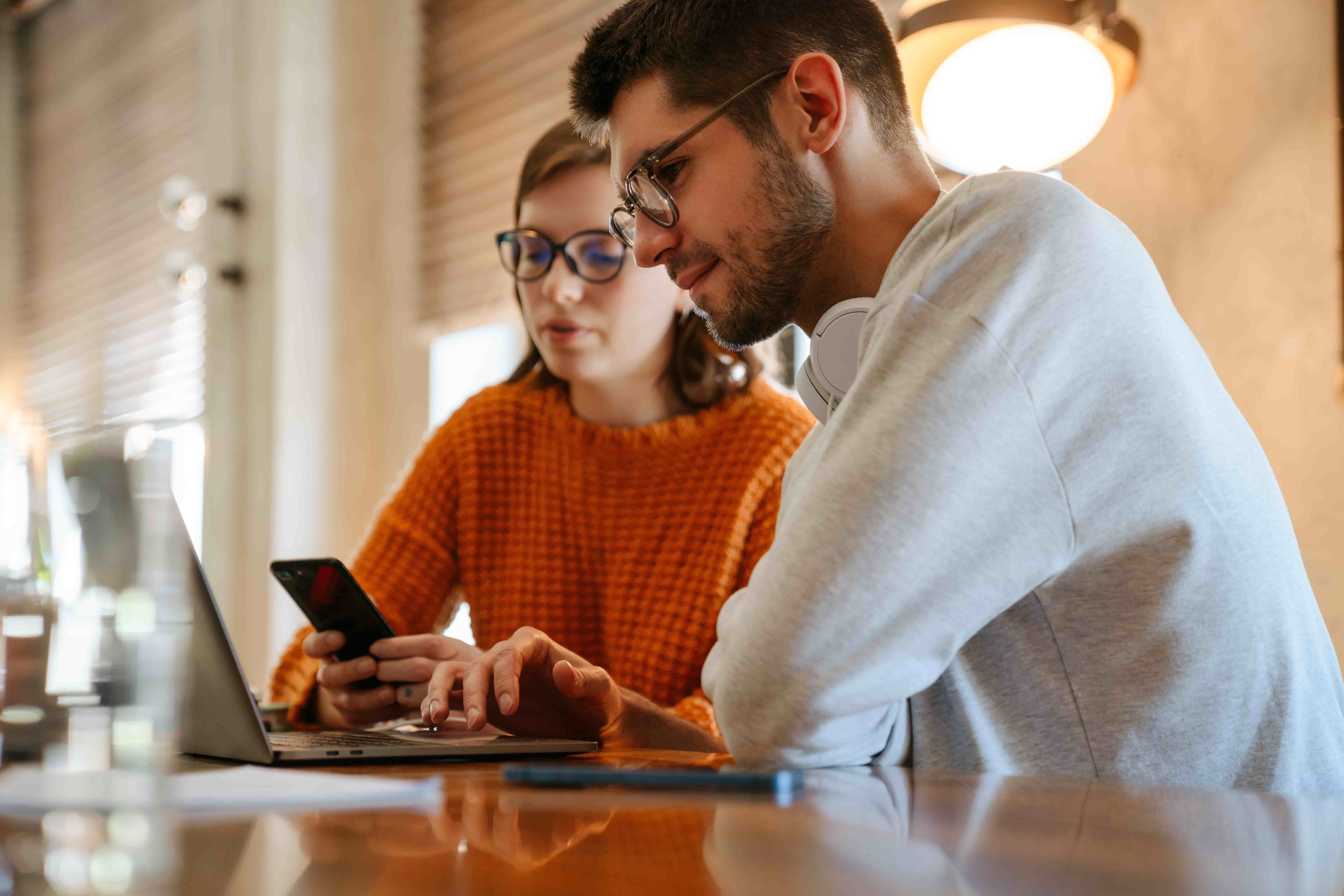 White young colleagues using gadgets while working together in office indoors